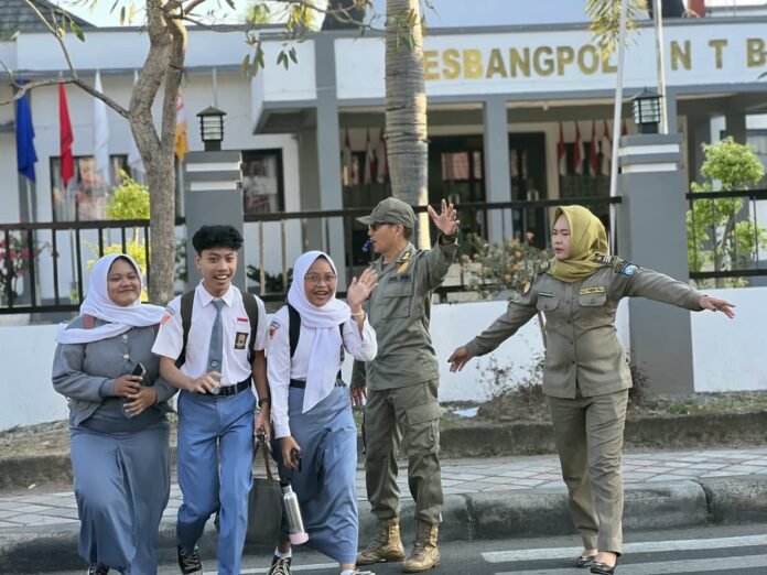 Satpol PP NTB Rutin Jaga Keamanan Lalu Lintas dengan Bantu Pelajar Menyeberang